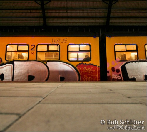 Een trein met graffiti staat langs het perron.